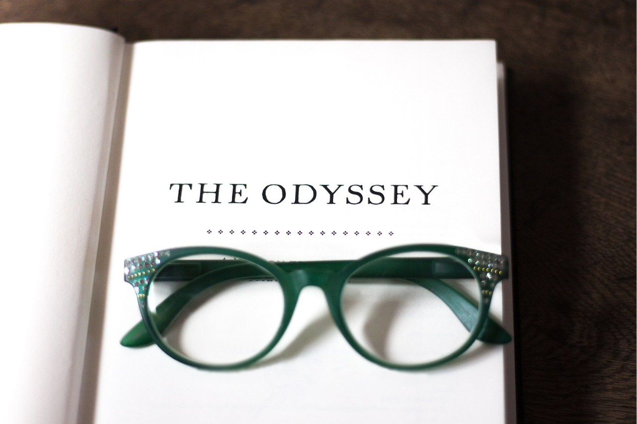 Green glasses resting on top of The Odyssey book - motifs in literature